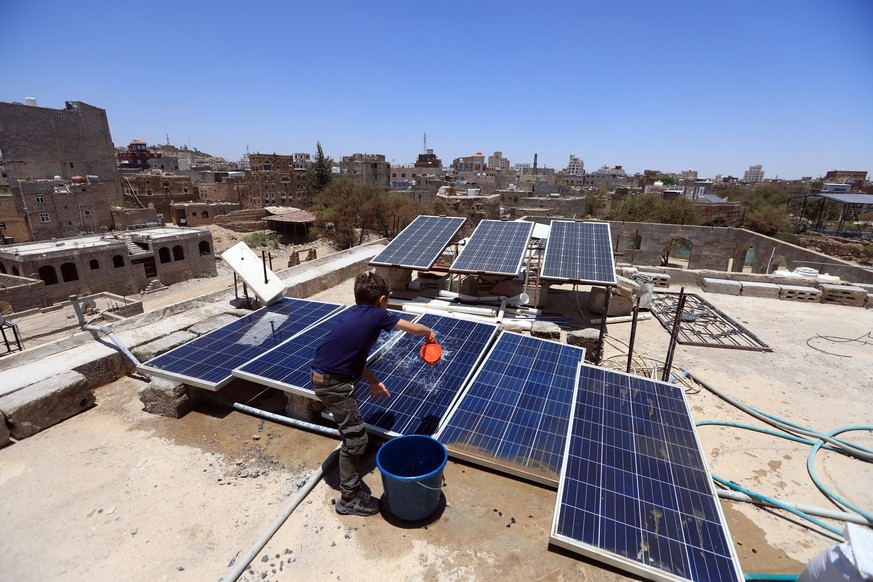 epa12046861 A boy cleans solar power panels on the rooftop of a house on Earth Day, in Sana&#039;a, Yemen, 22 April 2025. Earth Day is celebrated annually on 22 April, with this year&#039;s theme bein ...