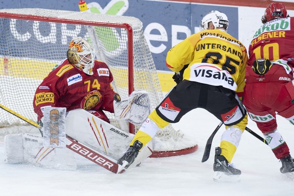 Tigers Goalie Ivars Punnenovs, und Janis Elsener, rechts, im Kampf um den Puck gegen Berns Ramon Untersander, Mitte, waehrend dem Qualifikations-Spiel der National League, zwischen den SCL Tigers und  ...