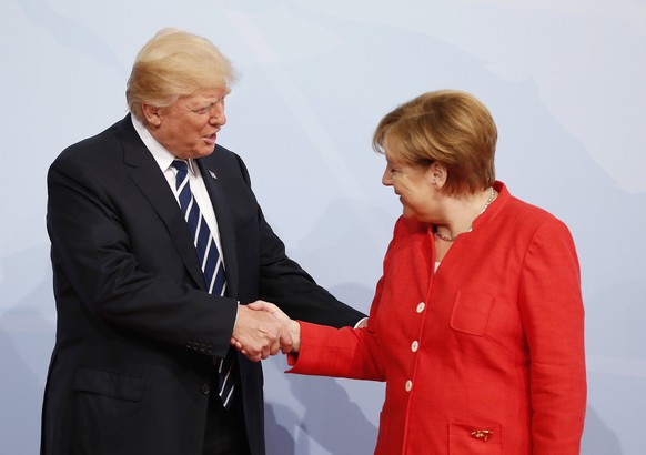 epa06072080 German Chancellor Angela Merkel (R) officially welcomes US President Donald J. Trump (L) to the opening day of the G20 summit in Hamburg, Germany, 07 July 2017. The G20 Summit (or G-20 or  ...