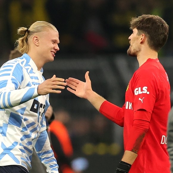 epa10266083 Dortmund goalkeeper Gregor Kobel (R) shakes hands with his former teammate and now Manchester City striker Erling Haaland after the UEFA Champions League group G match between Borussia Dor ...