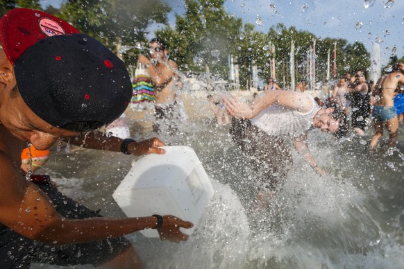 People throw water at each other during a 10-minute long water battle flash mob in Lausanne, Switzerland, Friday, July 3, 2015. The temperatures have been reaching over 35 degrees Celsius for several  ...