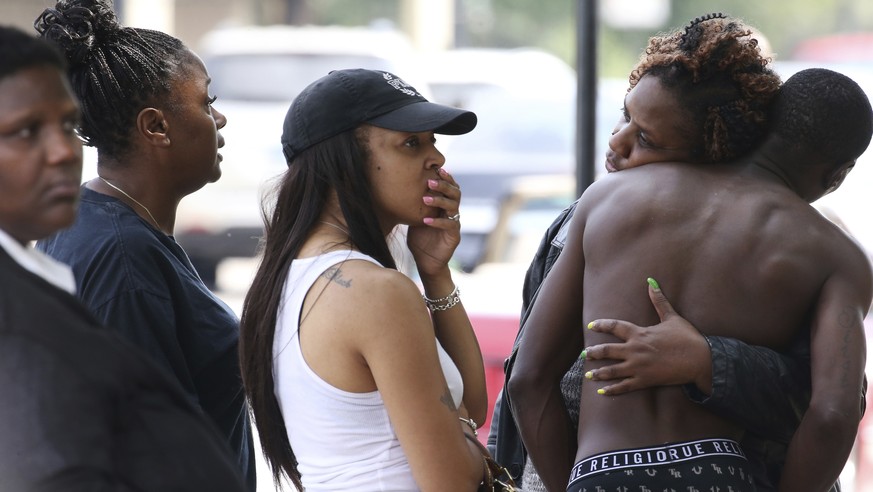 In this Sunday, Aug. 5, 2018 photo, dozens of people, who were forced outside or asked to leave, from the Stroger Hospital emergency waiting room area in Chicago, due to overwhelming crowds of family  ...