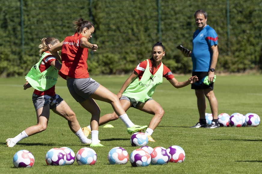 Switzerland&#039;s midfielder Riola Xhemaili, center, controls the ball past her teammates midfielder Sandrine Mauron, left, and forward Meriame Terchoun, right, during a training session of the subst ...