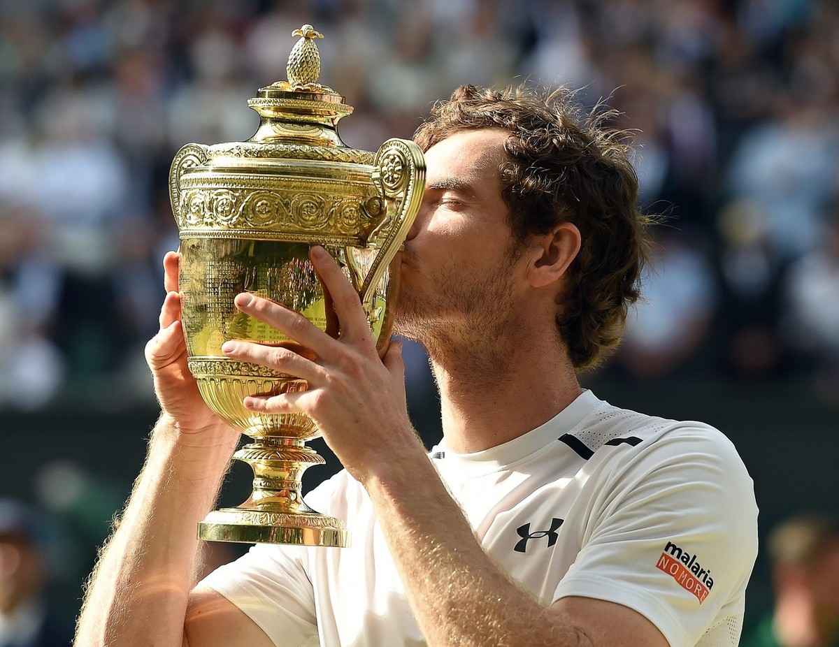 epa05418760 Andy Murray of Britain kisses the championship trophy following his win over Milos Raonic of Canada in the men's singles final of the Wimbledon Championships at the All England Lawn T ...