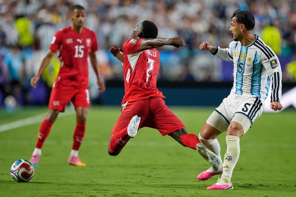 Switzerland's Breel Embolo (7) reacts in a challenge from Argentina's Leandro Paredes (5) during the World Cup quarterfinal soccer match between Argentina and Switzerland in Kansas City, Mo. ...