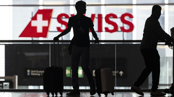 Menschen warten am Flughafen auf ihren Abflug in die Ferien, aufgenommen am Freitag, 8. Juli 2022 auf dem Flughafen in Zuerich. (KEYSTONE/Ennio Leanza)