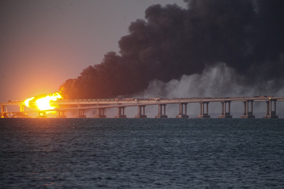 Flame and smoke rise fron Crimean Bridge connecting Russian mainland and Crimean peninsula over the Kerch Strait, in Kerch, Crimea, Saturday, Oct. 8, 2022. Russian authorities say a truck bomb has cau ...