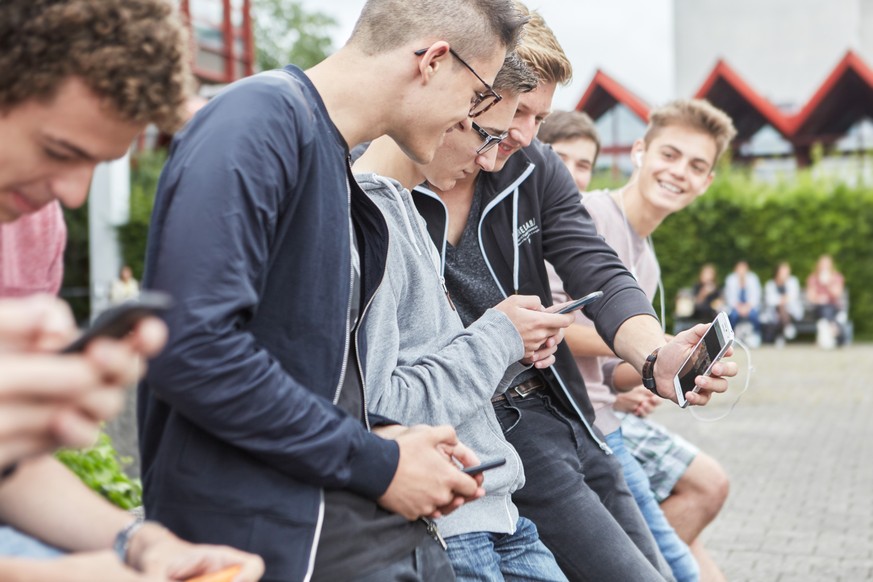 AZUM THEMA JUGENDLICHE UND MOBILTELEFON STELLEN WIR IHNEN HEUTE, DONNERSTAG, 14.01.2016, FOLGENDES BILDMATERIAL ZUR VERFUEGUNG --- group high school students use their smart phones on the schoolyard o ...