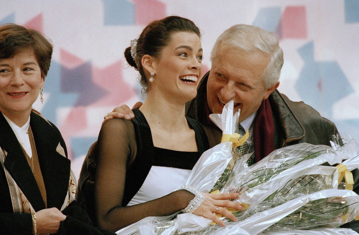 American figure skater Nancy Kerrigan gets congratulated by her coach Evy Scotvold following her performance in the women's technical program at Hamar, Norway, Feb. 23, 1994. Kerrigan sits in fir ...