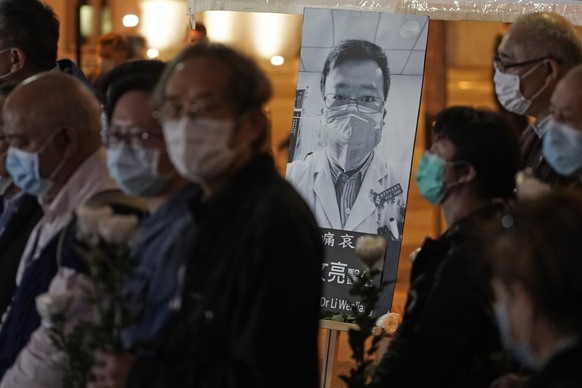 People wearing masks, attend a vigil for Chinese doctor Li Wenliang, in Hong Kong, Friday, Feb. 7, 2020. The death of a young doctor who was reprimanded for warning about China&#039;s new virus trigge ...