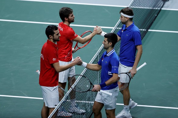 epa09619766 Nikola Mektic (2-L) and Mate Pavic (L) of Croatia are congratulated by Novak Djokovic (2-R) and Filip Krajinovic (R) of Serbia following their doubles tennis match at the semi final Davis Cup tie between Serbia and Croatia held at Madrid Arena tennis complex in Madrid, central Spain, 03 December 2021. EPA/Emilio Naranjo