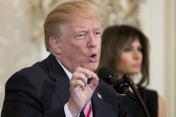 epa06522536 US President Donald J. Trump (L) gestures while delivering remarks beside First Lady Melania Trump (R), while hosting a reception in honor of National African American History Month, in th ...