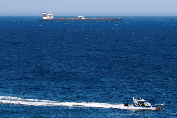 epa07779716 A British patrol boat is driven next to Iranian oil tanker Grace 1 as the ship prepares to depart from Gibraltar, southern Spain, 18 August 2019. The ship prepares to depart from Gibraltar ...