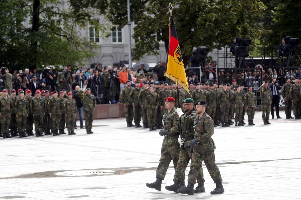 epa12125683 German army servicemen carry a Bundeswehr command flag during the inauguration of the German 45th Armoured Brigade 'Lithuania', at the Cathedral Square in Vilnius, Lithuania, 22  ...