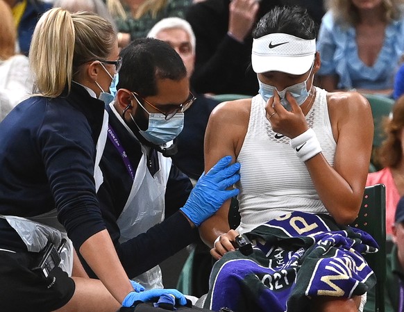 epa09324695 Emma Raducanu (R) of Britain receives medical assistance during her 4th round match against Ajla Tomljanovic of Australia at the Wimbledon Championships in Wimbledon, Britain, 05 July 2021 ...