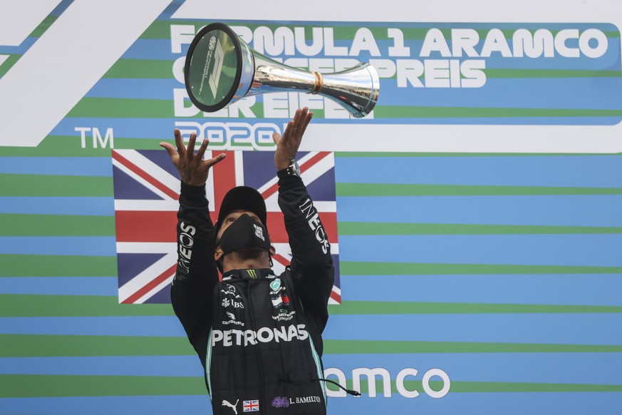 Mercedes driver Lewis Hamilton of Britain launches the trophy in the air on the podium after winning the Eifel Formula One Grand Prix at the Nuerburgring racetrack in Nuerburg, Germany, Sunday, Oct. 1 ...