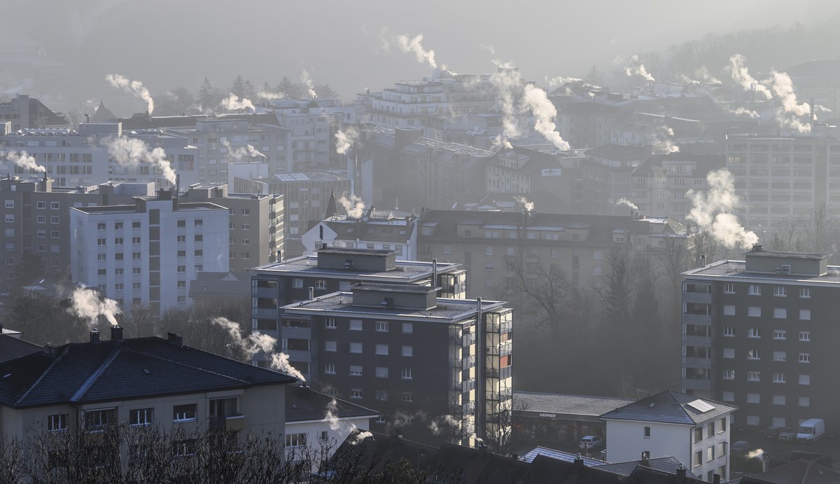 De la fumee s'echappe des cheminees sur les toits des immeubles, ce vendredi 14 janvier 2022 a Fribourg. (KEYSTONE/Anthony Anex)