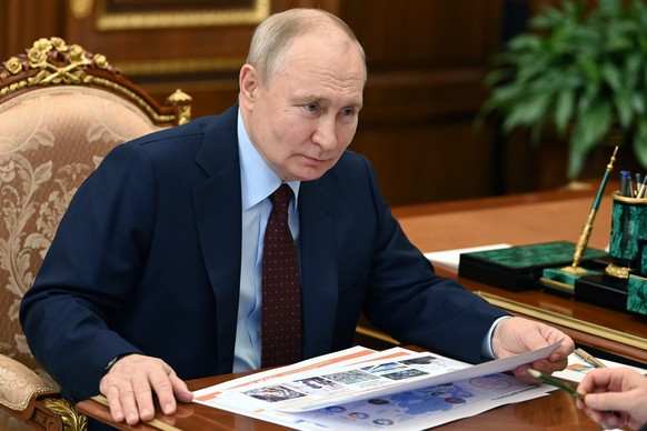 Russian President Vladimir Putin listens to Russian state nuclear corporation Director General of Rosatom Alexey Likhachev during their meeting in Moscow, Russia, Monday, Aug. 14, 2023. (Alexander Kaz ...
