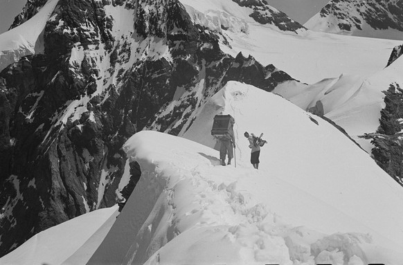 Zwei Mitarbeiter des PTT-Teams schleppen im Sommer 1948 Richtstrahlmaterial auf den Ostgrat der Jungfrau.