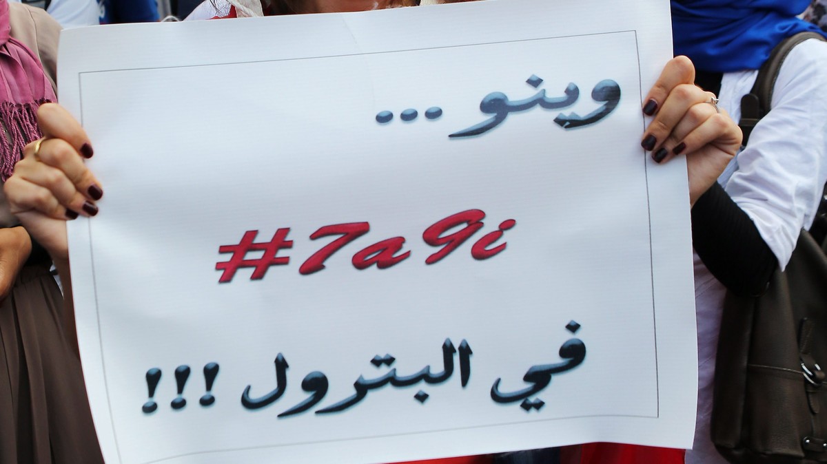 epa04776052 A Tunisian protester holds placard with the words in Arabic reading 'Where is the oil?' during a demonstration demanding greater transparency of the oil sector, Tunis, Tunisia on ...