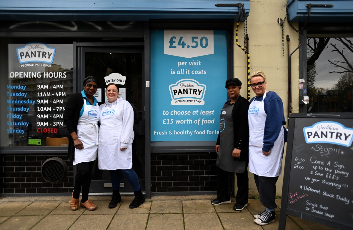 epa10592117 Pantry staff members pose for a photo in front of Peckham Pantry in London, Britain, 26 April 2023. People across the UK are using food banks and food Pantry stores more than ever accordin ...