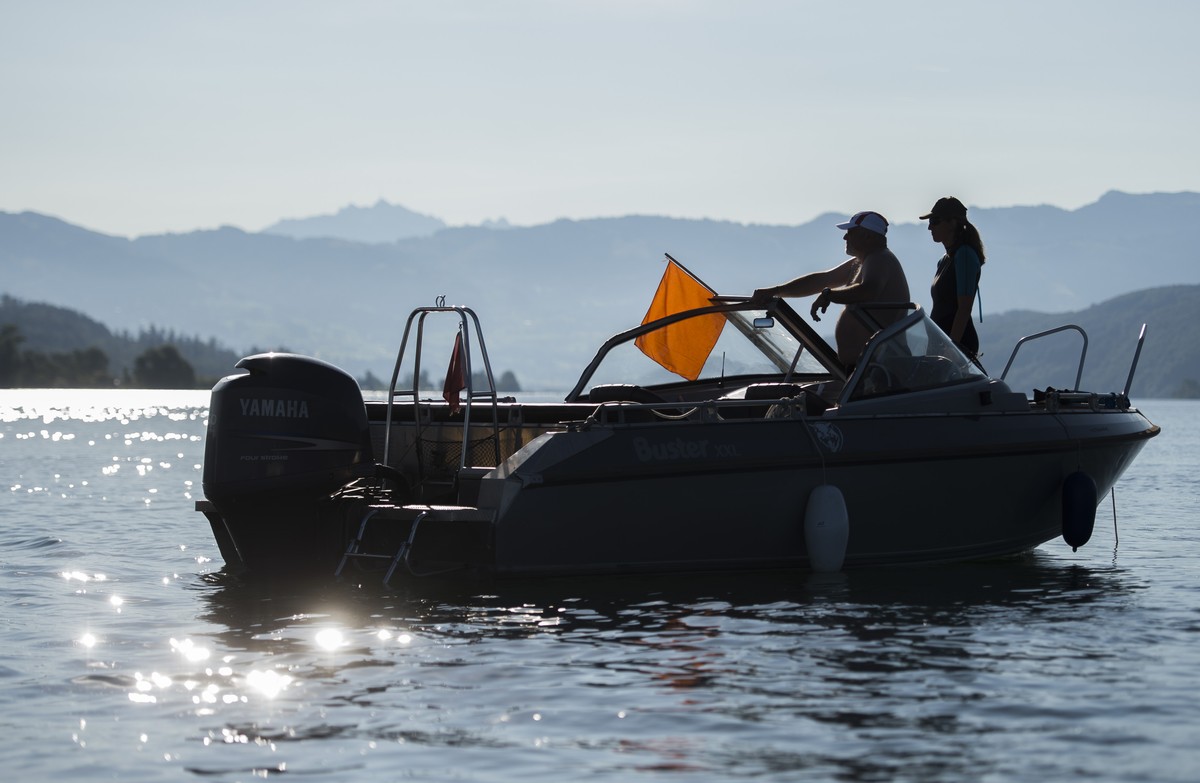 Zuschauer auf einem Boot beobachten den Ironman 70.3 am Sonntag, 7. Juni 2015 in Rapperswil. (KEYSTONE/Ennio Leanza)