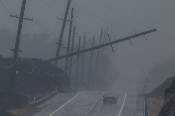 A vehicle drives near a downed utility pole dangling above Mamalahoa Highway during Hurricane Lala near Ocean View, Hawaii, Saturday, Aug. 15, 2026. (Stephen Lam/San Francisco Chronicle via AP)
Tropic ...