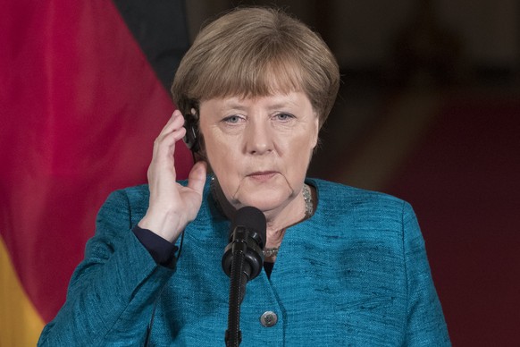 epa05854957 Chancellor of Germany Angela Merkel uses an earpiece during a joint news conference with US President Donald J. Trump (not pictured) in the East Room of the White House in Washington, DC,  ...