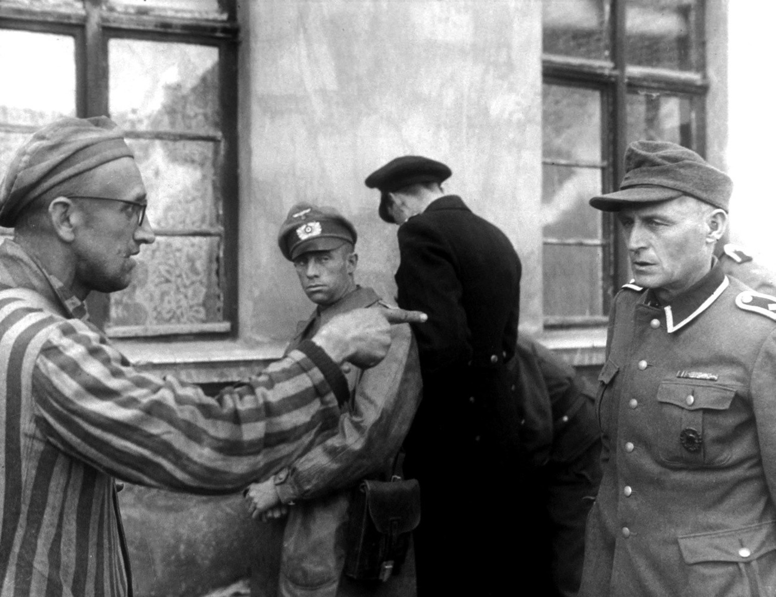 Zweiter Weltkrieg, Befreiung des Konzentrationslagers Auschwitz-Birkenau vom 27. Januar 1945. Ein Ueberlebender des KZ sagt einem SS-Mann dessen Verbrechen auf den Kopf zu und zeigt mit dem Finger auf ...