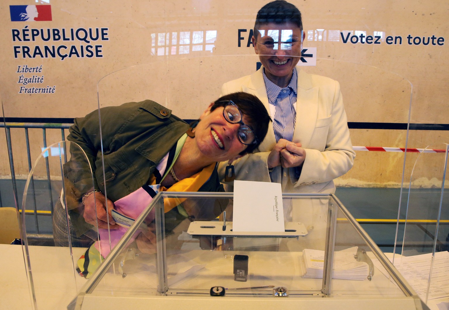 Volunteers react during the first round of the French presidential election, in Saint Pee sur Nivelle, France, Sunday, April 10, 2022. The polls opened at 8am in France for the first round of its pres ...