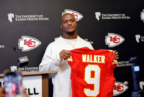 Kansas City Chiefs' new running back Kenneth Walker III holds up a jersey as he is introduced during an NFL football news conference, Thursday, March 12, 2026, in Kansas City, Mo. (AP Photo/Colin ...