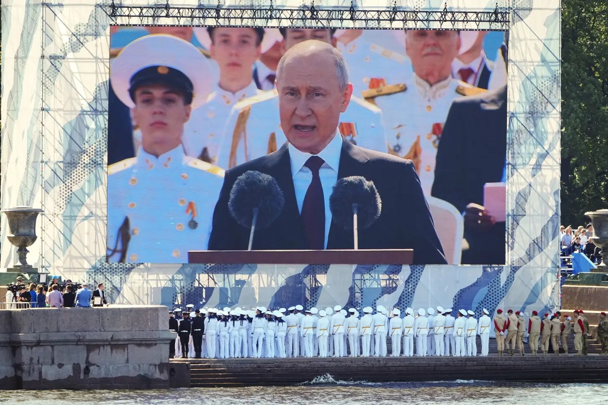 Des marins de la marine russe suivent le chef du Kremlin Vladimir Poutine sur grand écran lors de la Journée de la Marine à Saint-Pétersbourg.