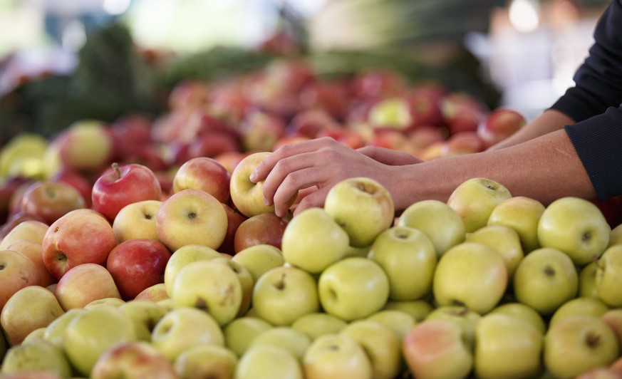 In this photo taken Oct. 5, 2014, apples are displayed at a farmers market in Arlington, Va. A common pesticide used on citrus fruits, almonds and other crops would be banned under a proposal announce ...