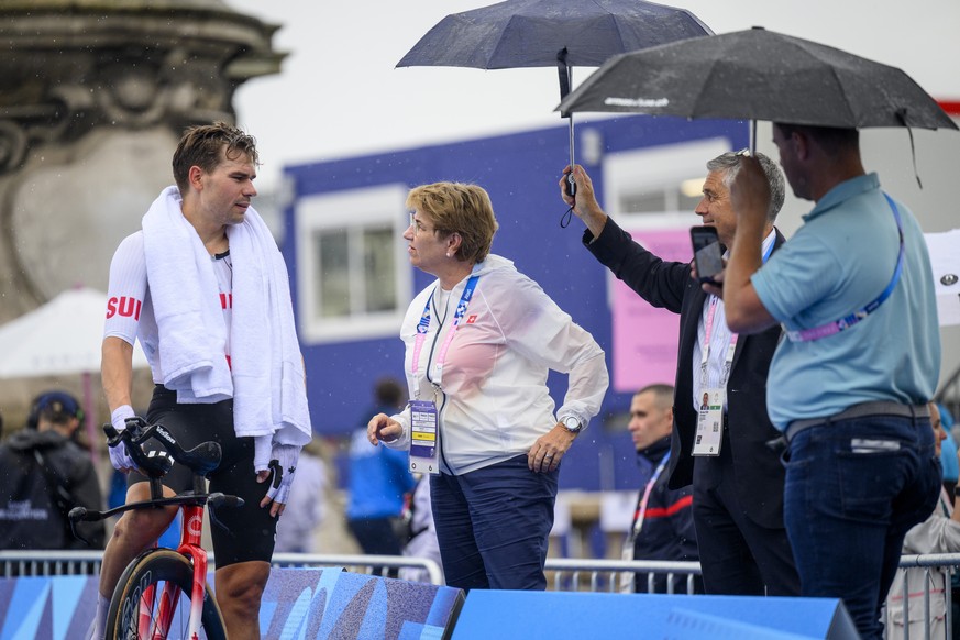 Stefan Bissegger of Switzerland, left, speaks with Swiss President and Federal Councillor Viola Amherd, center, after crossing the finish line during the men's cycling individual time trial at th ...