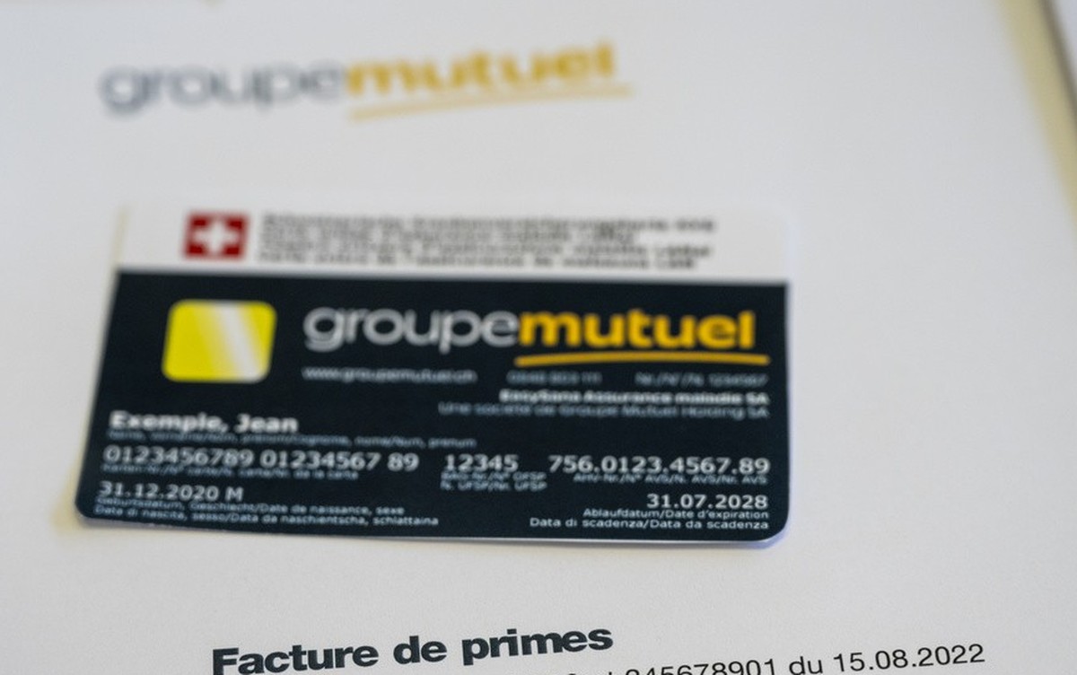 Une illustration montre une facture fictive de primes maladie et une carte d'assurance fictive contenant le nouveau logo de la compagnie d'assurance Groupe Mutuel le mercredi 21 septembre 20 ...