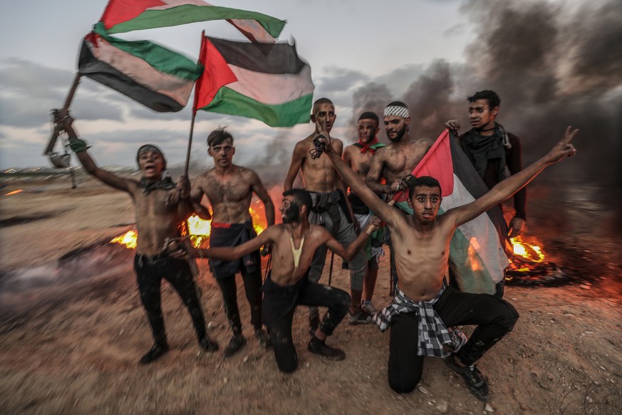 epa07122225 Palestinian protesters during the clashes near the border between Israel and Gaza Strip in the east Gaza City, 26 October 2018. Five Palestinians protesters were killed and more than 170 o ...