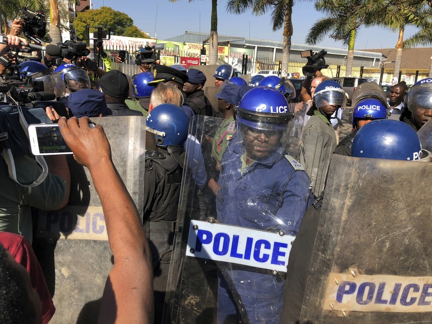 Riot police break up a press conference by opposition leader Nelson Chamisa in Harare, Zimbabwe, Friday Aug. 3, 2018. Hours after President Emmerson Mnangagwa was declared the winner of a tight electi ...