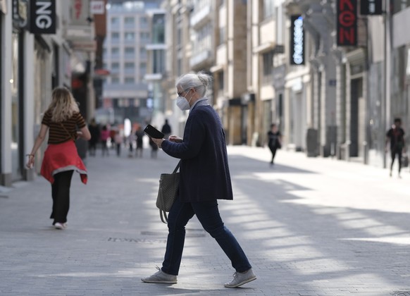 epa08386853 A woman wearing a face mask in main shopping street Nieuwstraat / Rue Neuve, in Brussels, Belgium, 27 April 2020. Belgium plans to partially lift lockdown measures from 04 May on, allowing ...