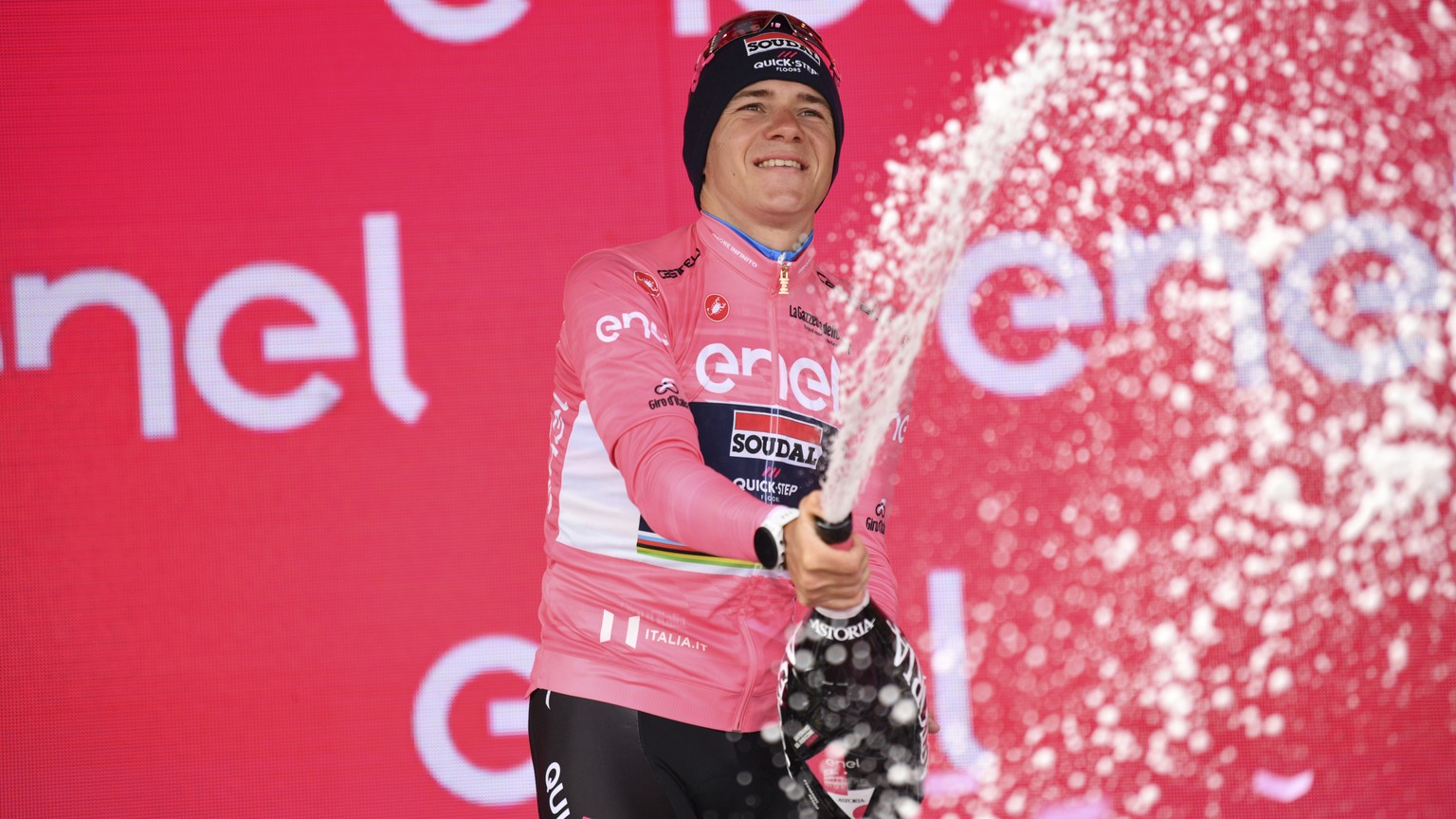 Remco Evenepoel wears the pink jersey of the race overall leader as he celebrates on podium after winning the 9th stage of the Giro D&#039;Italia, tour of Italy cycling race, an individual time trial  ...