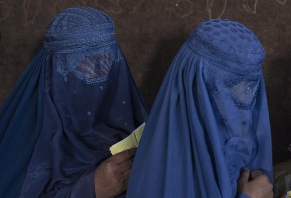 Afghan women wait to receive cash at a money distribution point organized by the World Food Program, in Kabul, Afghanistan, Saturday, Nov. 20, 2021. Many Afghan families who once had steady, stable in ...