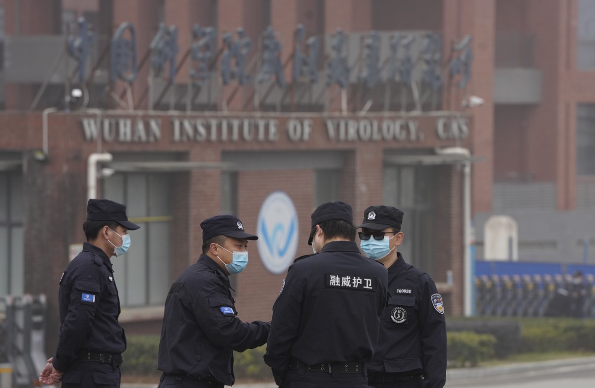 Security personnel gather near the entrance of the Wuhan Institute of Virology during a visit by the World Health Organization team in Wuhan in China's Hubei province on Wednesday, Feb. 3, 2021.  ...