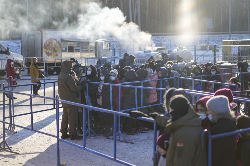 Migrants queue to receive hot food at the &quot;Bruzgi&quot; checkpoint logistics center at the Belarus-Poland border near Grodno, Belarus, Wednesday, Dec. 22, 2021. Since Nov. 8, a large group of mig ...