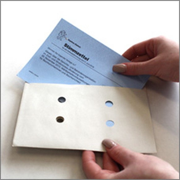 Ausgefüllten Stimmzettel ins Stimmcouvert stecken und dieses danach zukleben. 