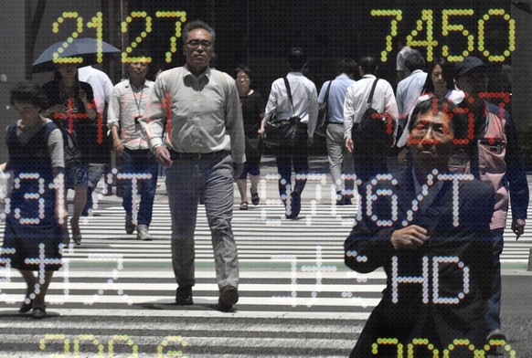 epa05393661 Pedestrians are reflected in a stock market indicator board in Tokyo, Japan, 27 June 2016. Tokyo stocks rebounded in the morning trading session after losing 8 percent on 24 June following ...