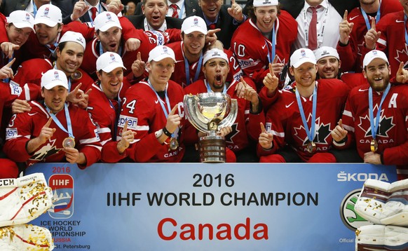 epa05324238 Players of Canada pose for photographers with the trophy after the Ice Hockey World Championship 2016 final between Finland and Canada at the Ice Palace in Moscow, Russia, 22 May 2016. Can ...