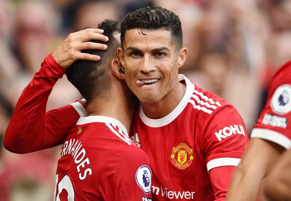 epa09461702 Bruno Fernandes of Manchester United (L) is being congratulated by teammate Cristiano Ronaldo after scoring his team&#039;s third goal during the English Premier League soccer match betwee ...