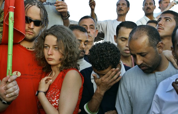 FILE - In this April 26, 2006 file photo, tourists and Egyptians react as they commemorate the victims in Dahab, Egypt, at the site where one of three bombs ripped through Egypt's Red Sea resort ...