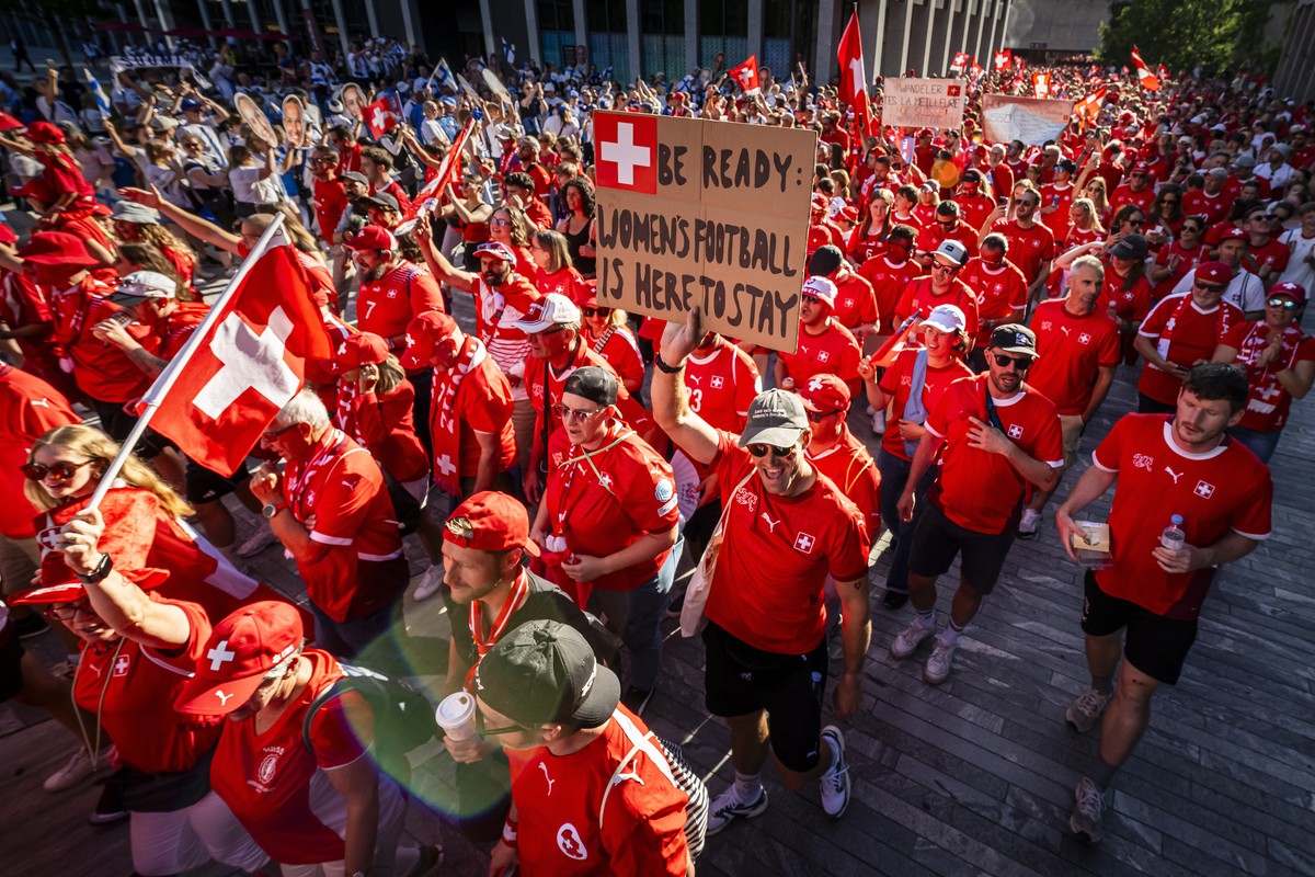 epa12229903 A person carry a placard reading 'Be ready: Women's Football is here to stay' as supporters of Switzerland attend a fanwalk prior to the UEFA Women's EURO 2025 Group A  ...