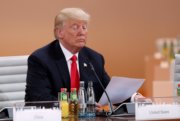 epa06075535 US President Donald Trump reads a document prior to the morning working session on the second day of the G20 economic summit in Hamburg, Germany 08 July 2017. The G20 Summit (or G-20 or Gr ...