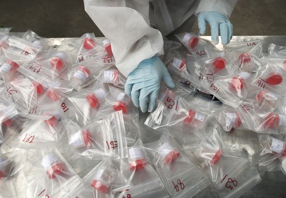 epa09121827 A Thai health official collects specimen bottles during a saliva collection test for COVID-19 amid the new wave of the coronavirus pandemic in Bangkok, Thailand, 08 April 2021. Authorities ...